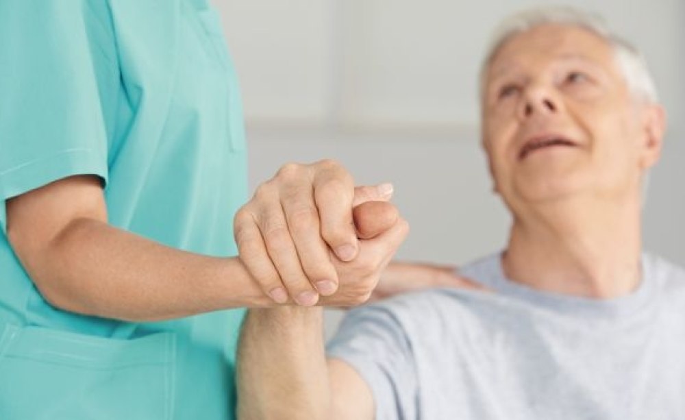 Mehr Lebensqualität für die Patienten: Das Thema Mundgesundheit gewinnt an Bedeutung, wenn Zahnärzte regelmäßig vor Ort sind. Alter Mann greift Hand