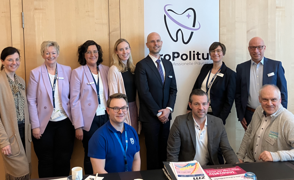 Beiratstreffen der Initiative ProPolitur (obere Reihe von links): Birgit Hühn (VDDH), Sylvia Fresmann (DGDH), Heike Wilken (DGDH), Mariette Altrogge (VDDH), Dr. Christoph Kossack (ParoStatus.de), Dr. Kristina Hänel (Dürr Dental) und Andreas Beul (HuFriedyGroup). Untere Reihe von links: Fabian Urban (Philips), Marc Diederich (Dürr Dental) und Dr. Burkhard Selent (CP Gaba). Nicht im Bild: Sebastian Kritzinger und Stefan Rippel (W&H), Sabine Zude (CGM Dentalsysteme) und Benedikt Ehrenfeld (Kerr). Menschengruppe vor dem ProPolitur-Logo