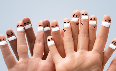Hände Finger bemalt mit Gesichtern und Masken
